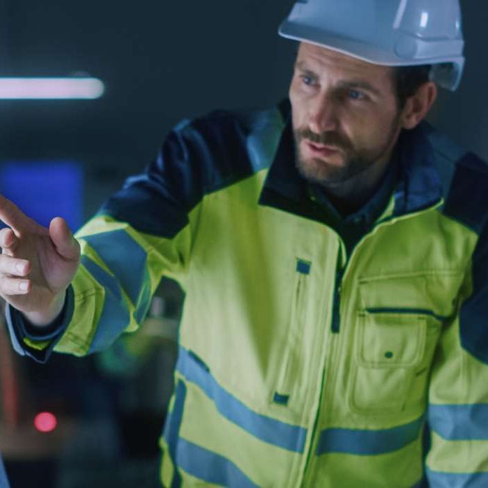 To fabrikkarbeidere planlegger smart industri sikkerhet på en dataskjerm.